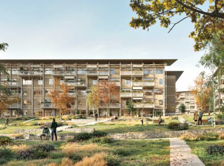 Timber Housing: Modern apartment buildings with large balconies overlook landscaped grounds with people walking, sitting, and biking among autumn trees and grassy areas.