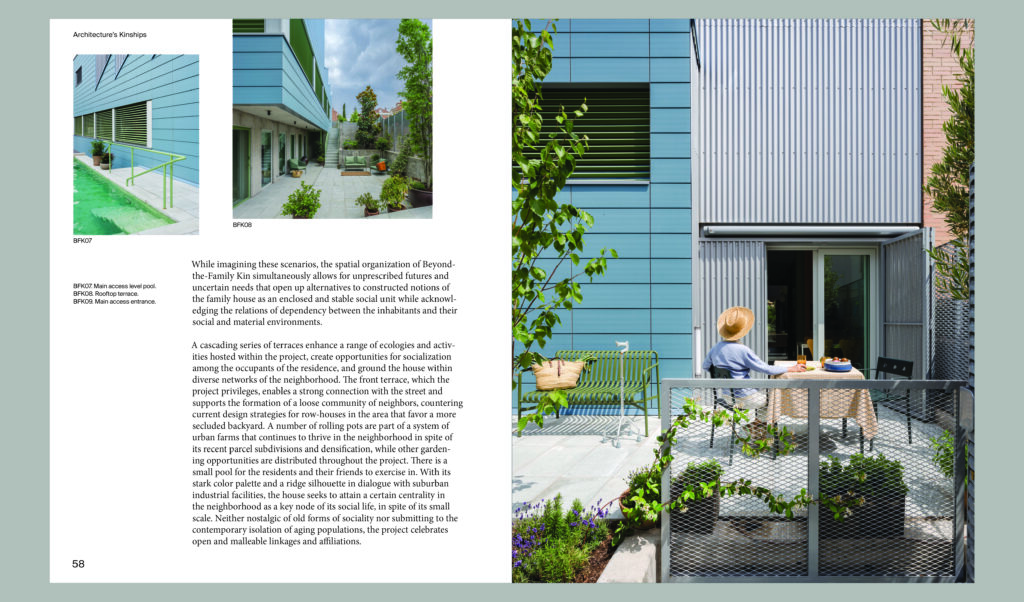 A person sits at a patio table on a small terrace beside a modern building with metal siding and green accents, surrounded by plants and a metal fence—an inviting example of Antifascist Architecture blending openness, community, and contemporary style.