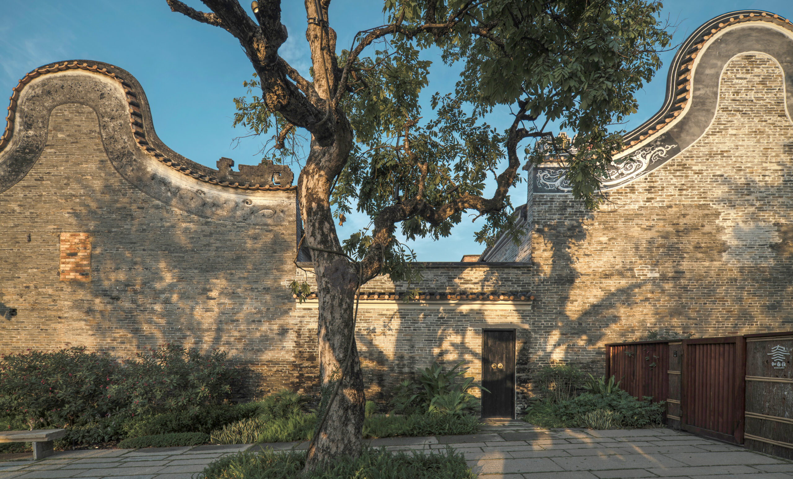 Sculptural, sweeping silhouette of ancient brick walls at Langtou Village Inn in China