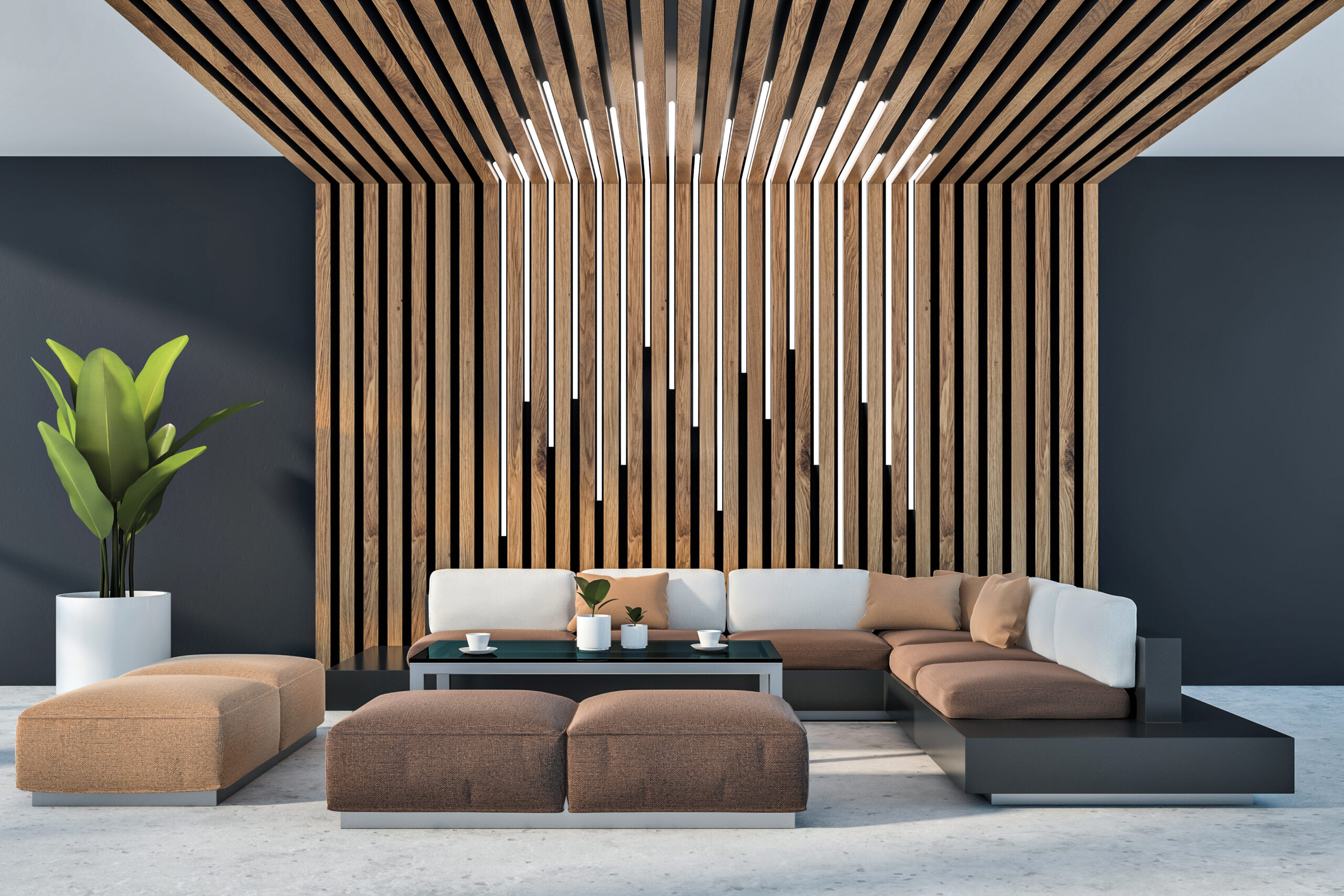 Products to Specify: Modern lounge with a sectional sofa, coffee table, potted plant, and a ceiling of vertical wooden slats with hanging linear light fixtures.