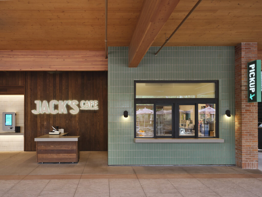 Exterior view of Jack’s Café with a wooden counter, green tiled wall, illuminated sign, and a pickup window next to a “Pickup” sign—just steps away from the Lucas Museum of Narrative Art.
