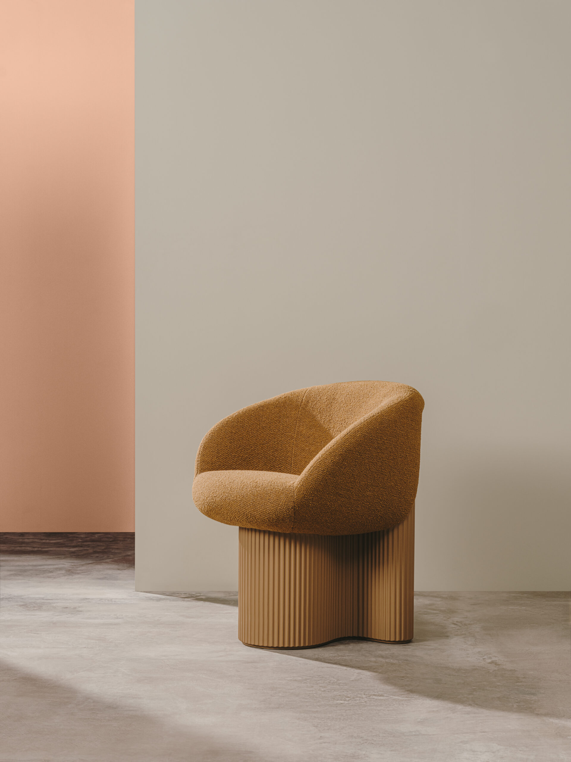 A modern armchair with a curved back and textured mustard-yellow upholstery sits on a ribbed wooden base against a neutral and peach-toned background.