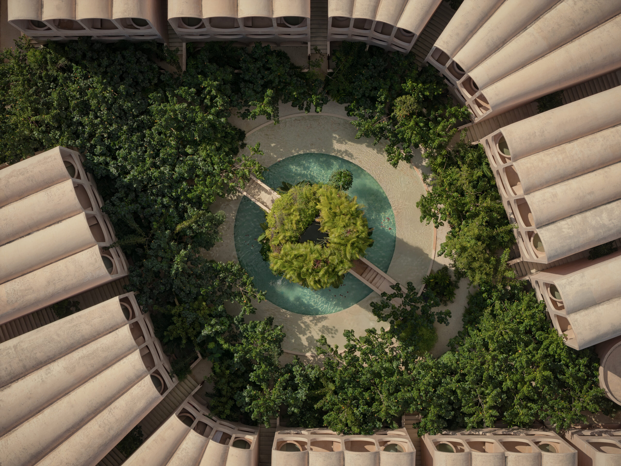 Birds eye view of lush green courtyard in modern housing complex by V Taller, bordering the jungle.