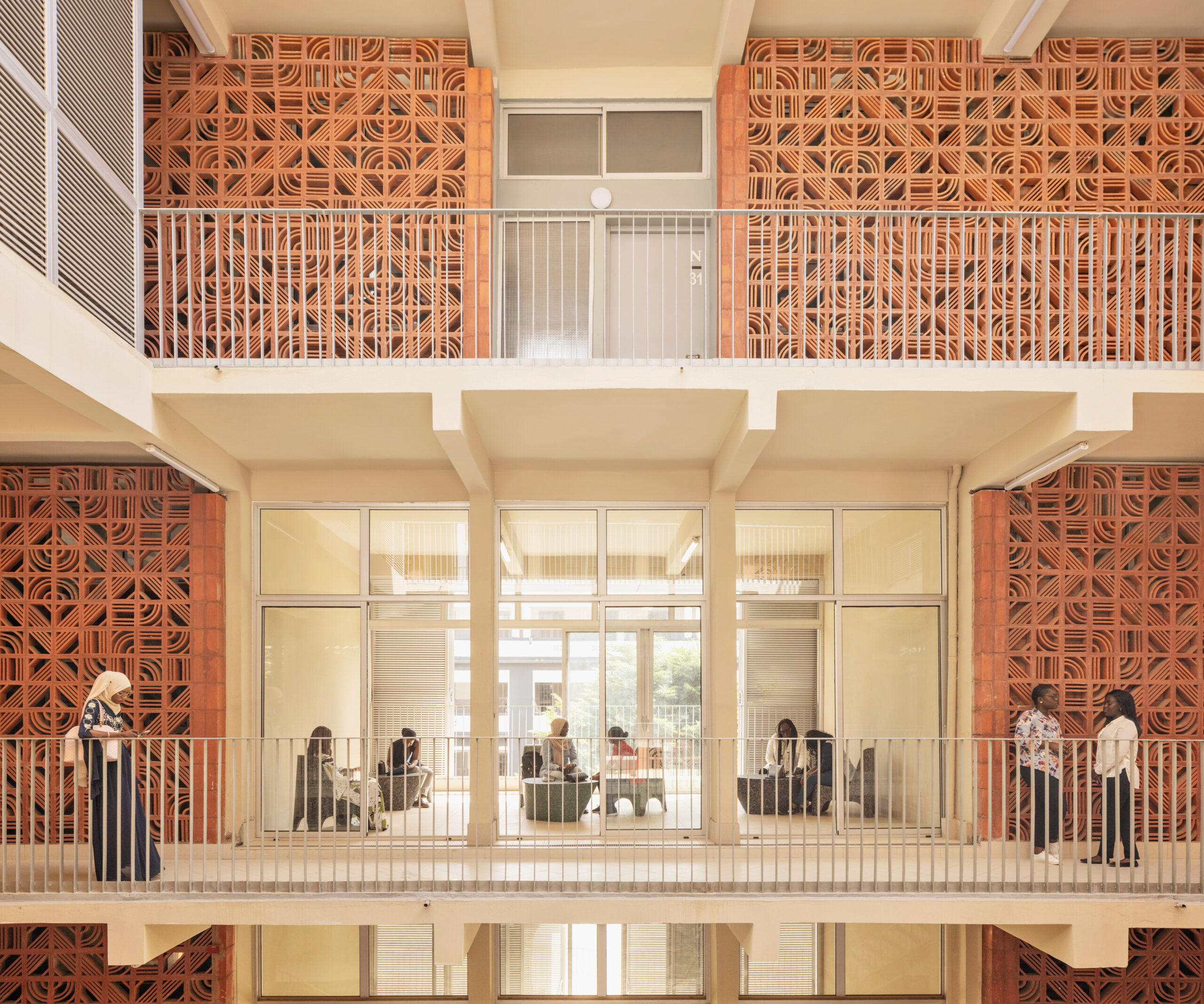 A student housing residence with a terracota-colored perforated brick design on each storey in an open-concept layout.
