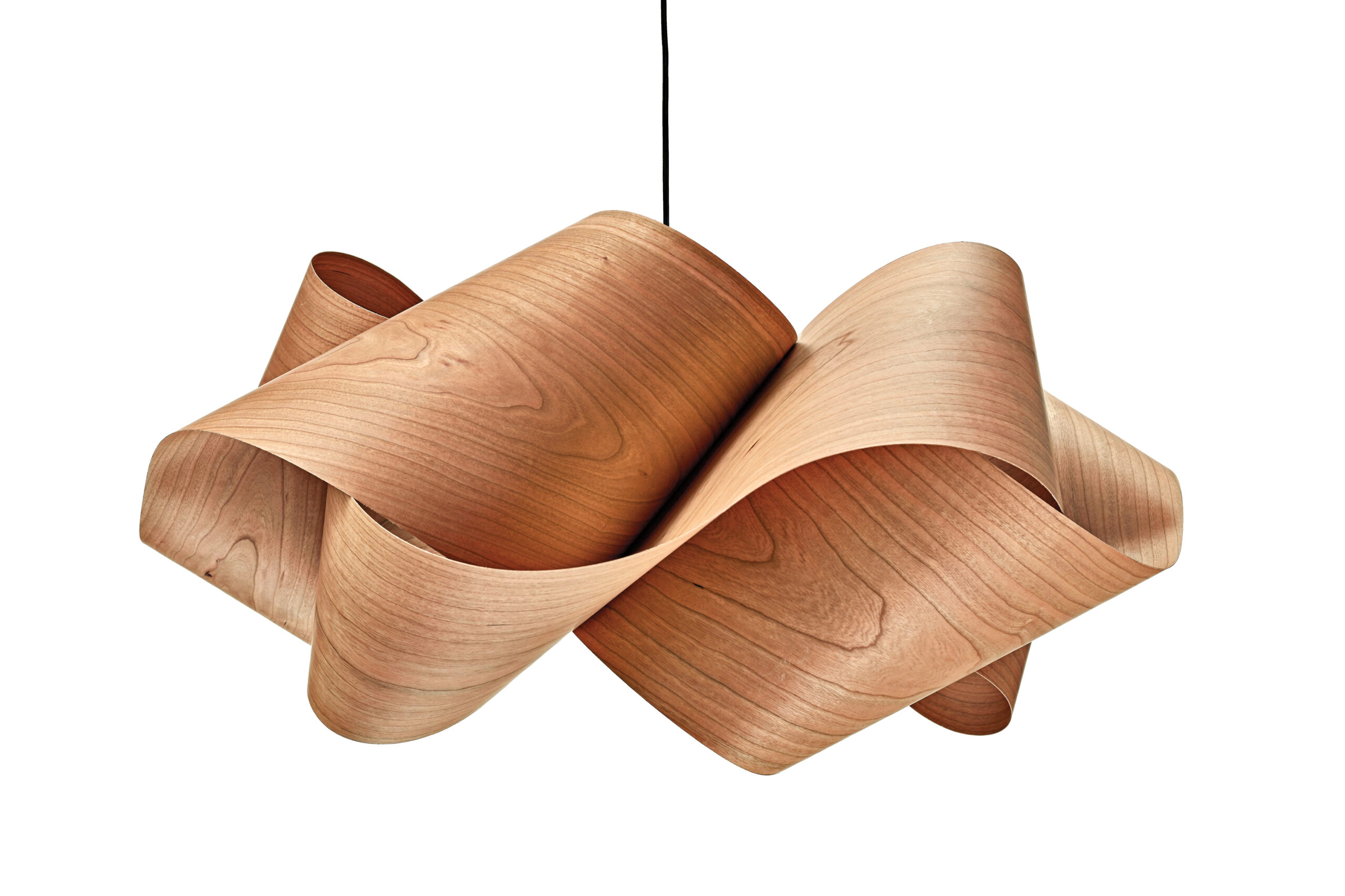 Products to Specify: Pendant lamp made of bent, light-colored wood veneer forming an abstract, ribbon-like shape, hanging from a black cord against a white background.