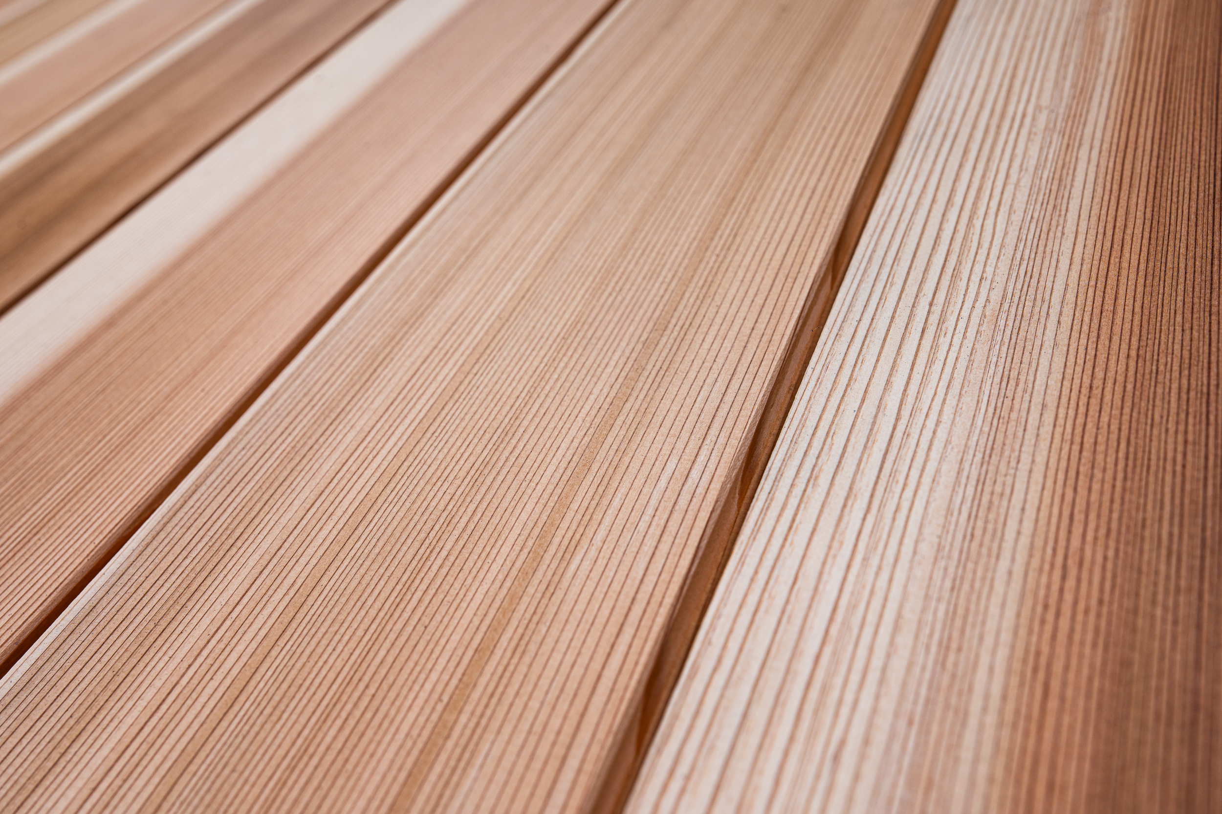 Close-up of several parallel wooden planks with a grooved texture, likely used for decking or flooring.