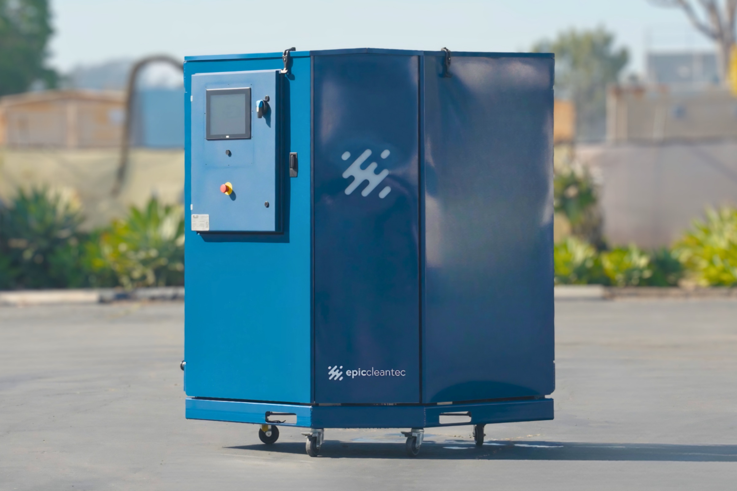 A blue industrial machine with a control panel and wheels labeled “epicleantec” stands outdoors on a paved surface.