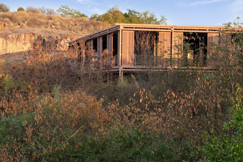The Barbara and Gerson Bakar Gateway at UC Berkeley features a modern, slatted structure sitting on a hillside surrounded by dry brush and trees.