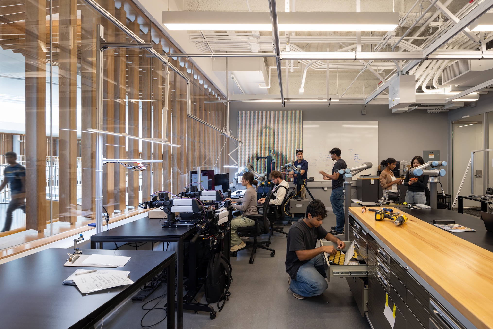 People work at desks and operate robotic arms in a laboratory setting at the Lucas Museum of Narrative Art.