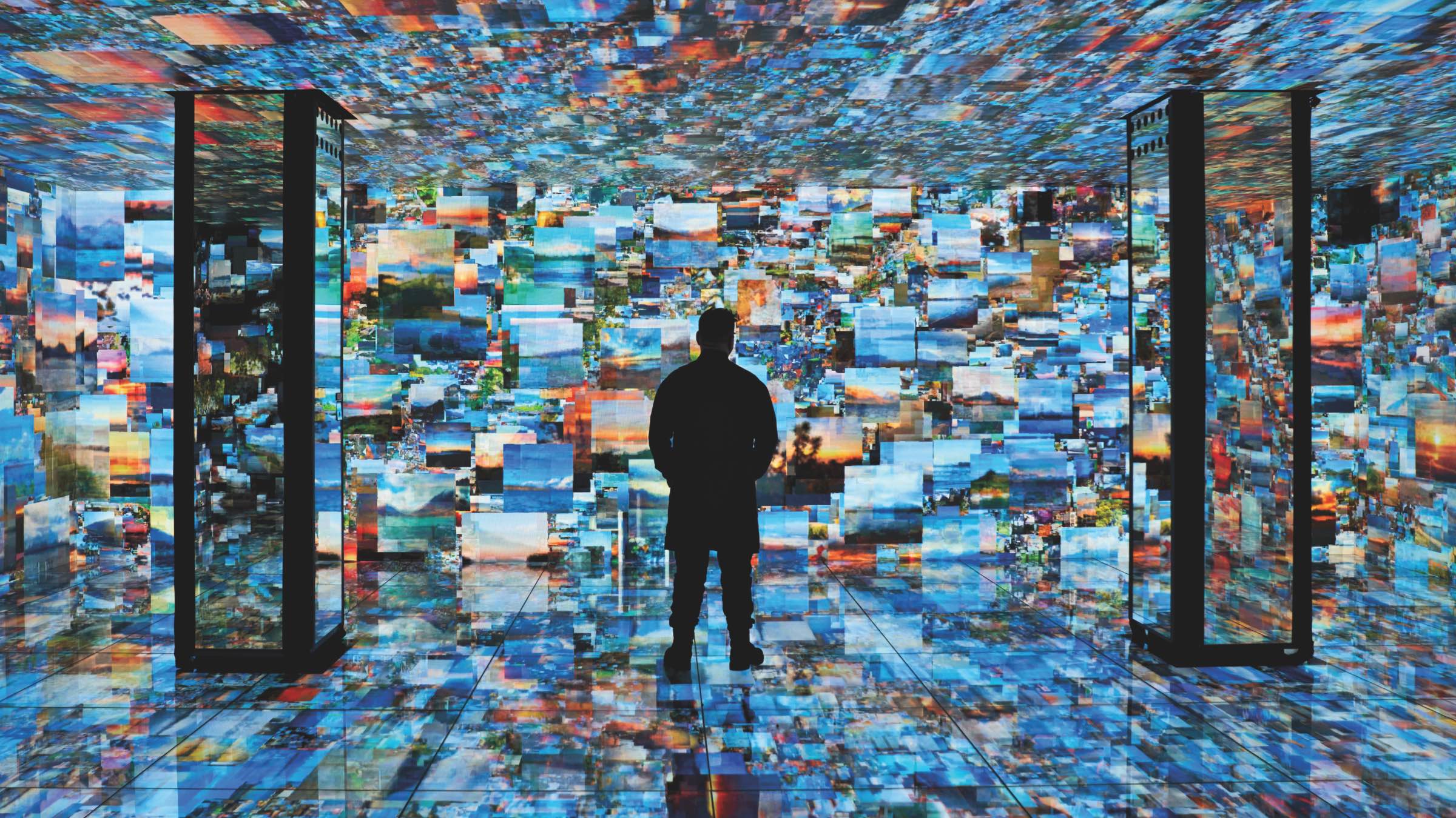 Design for Autism: A person stands in a room surrounded by a digital projection of numerous landscape photographs covering the walls, ceiling, and floor.
