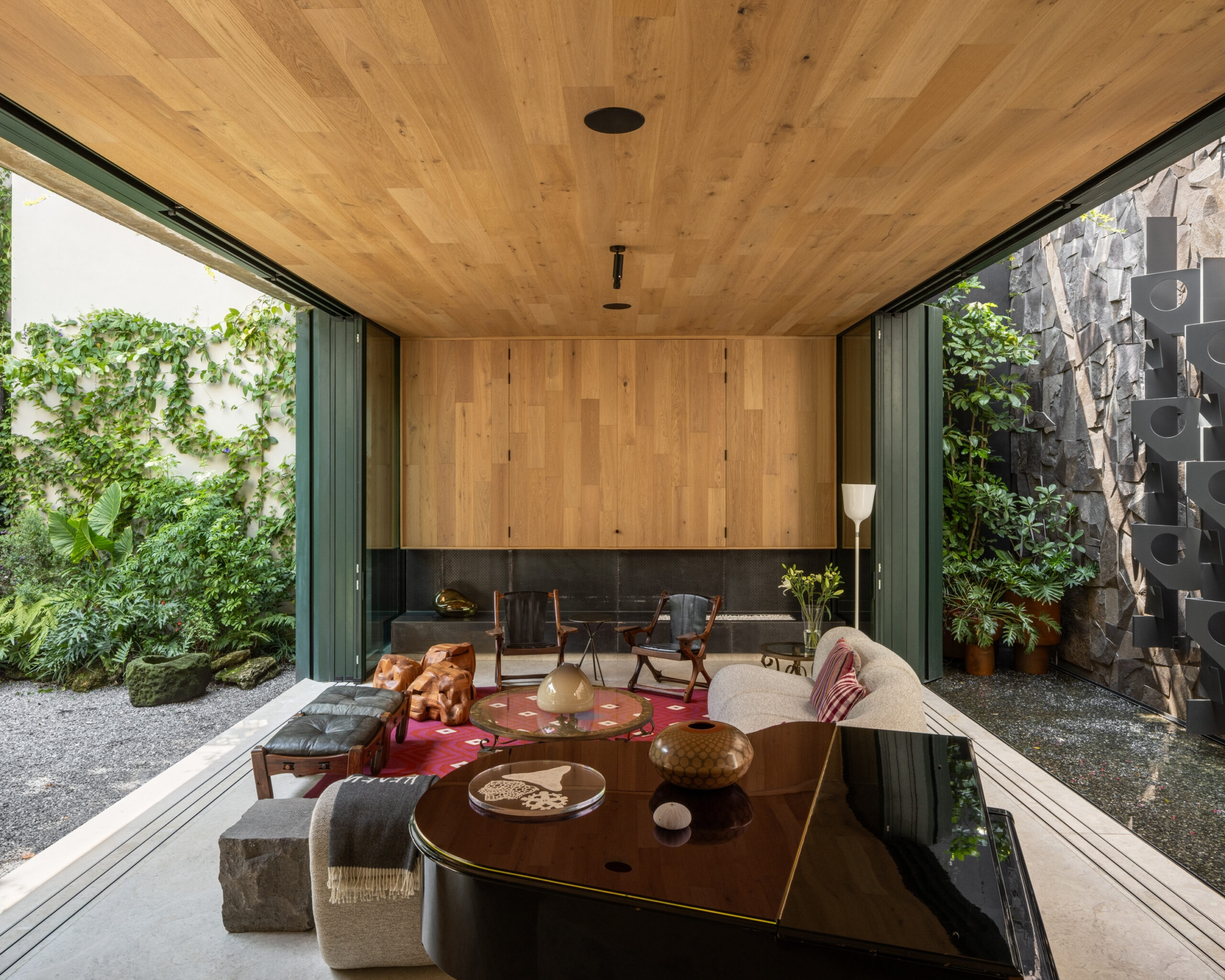 Living room with an open floor plan, a grand piano, seating, and views of two outdoor garden courtyards.