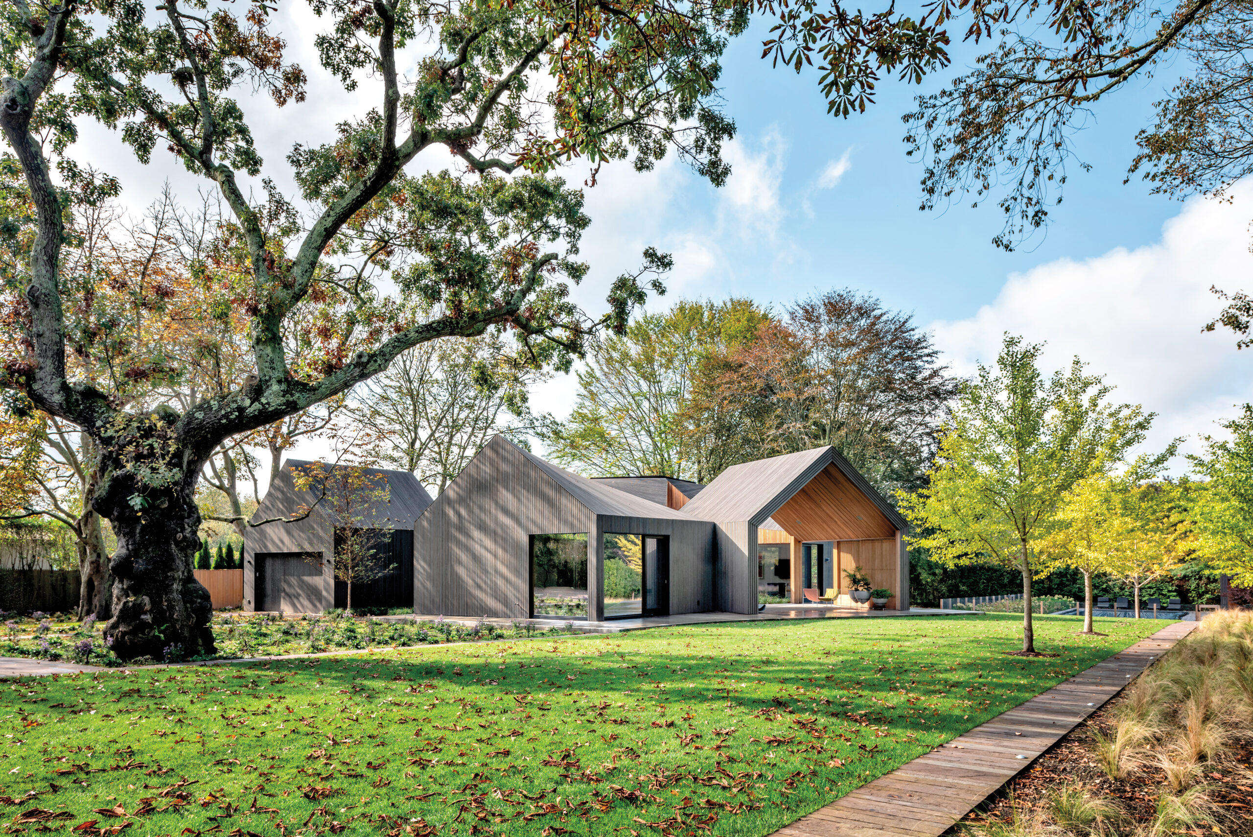 Young Projects: a modern farmhouse with housing modules arranged so their roof ridges align, creating continuity from one volume to the next around an interior courtyard.